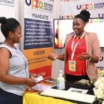 A Staff member at UFZA interacts with one of the Trade Show-goers at the UFZA stall during the 28th Uganda International Trade Fair 2022.