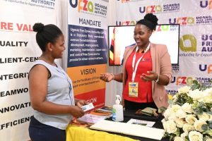 A Staff member at UFZA interacts with one of the Trade Show-goers at the UFZA stall during the 28th Uganda International Trade Fair 2022. 